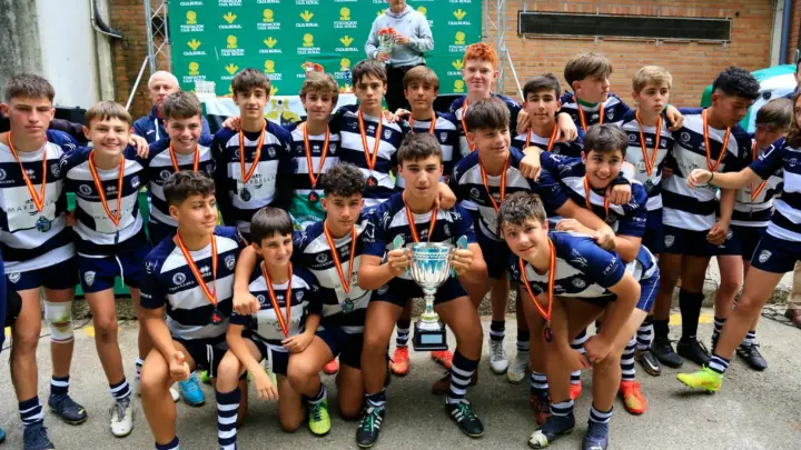 Equipo de rugby M14 celebrando un título con trofeo y medallas tras un campeonato nacional