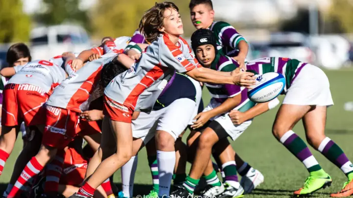 Niños jugando un partido de rugby base en acción durante una melé en competición infantil