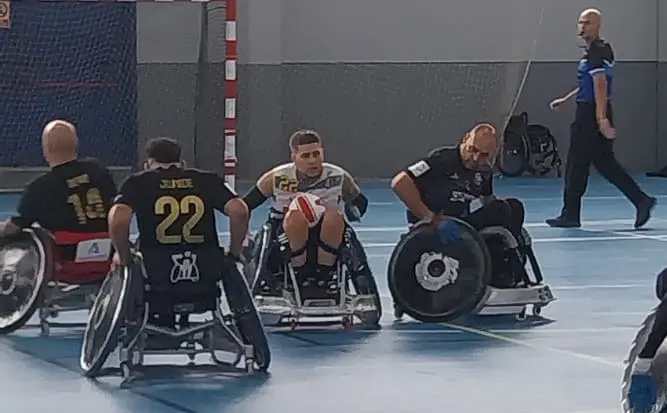 Un jugador avanza con el balón entre jugadores del Dragones del CAAD en un partido de rugby en silla de ruedas